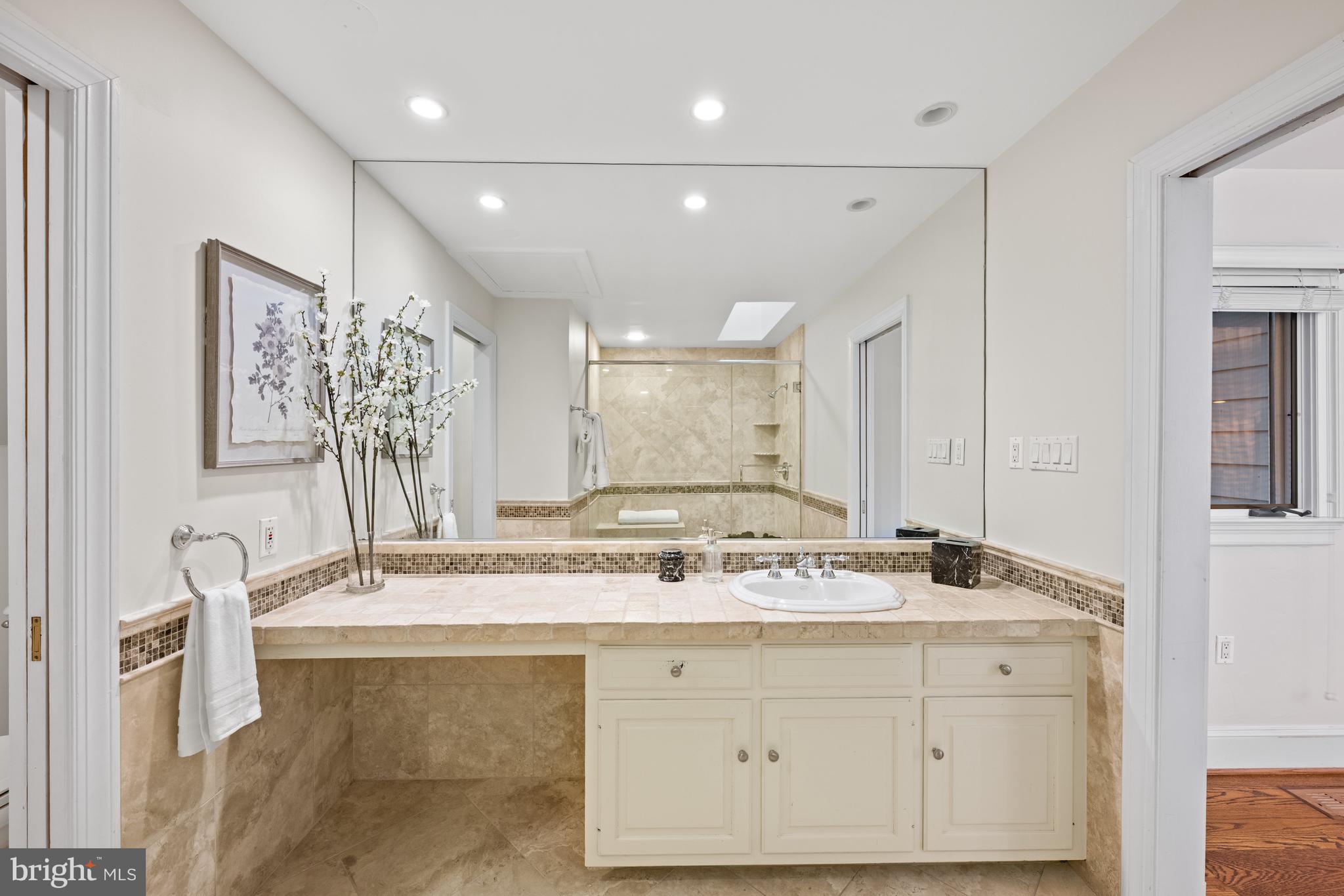 11552 Springridge Road Potomac, MD 20854 - Photo 37 of 65 a bathroom with a granite countertop sink a mirror and a shower