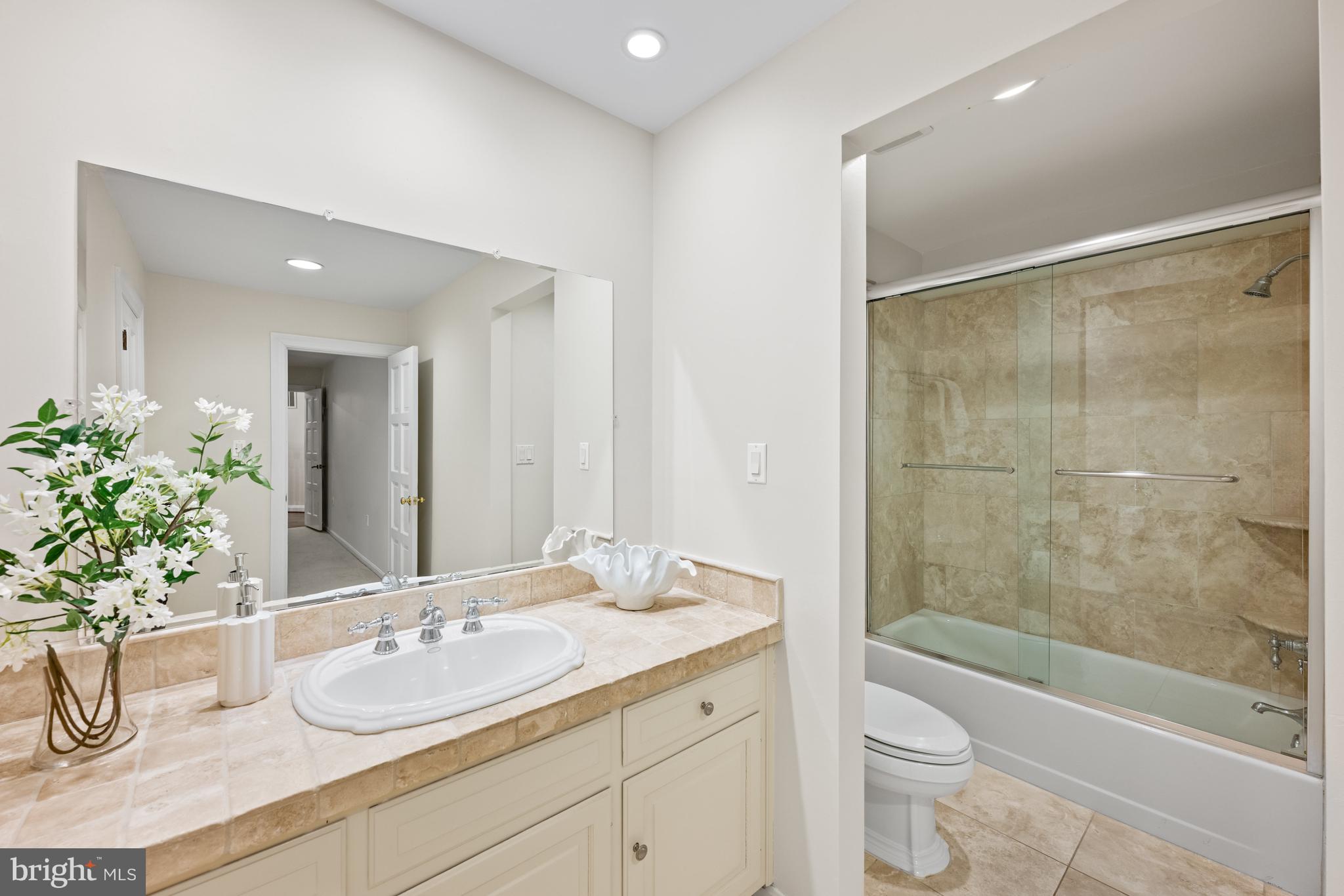 11552 Springridge Road Potomac, MD 20854 - Photo 39 of 65 a bathroom with a granite countertop sink toilet mirror and shower