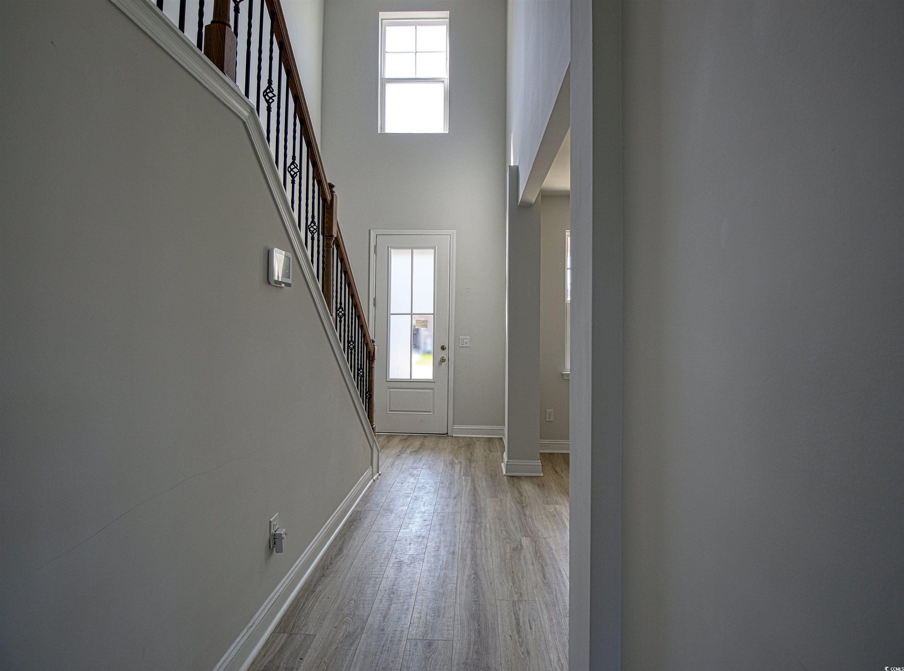 504 Patapsco Street Little River, SC 29566 - Photo 7 of 21 Foyer entrance featuring light wood-style floors, a high ceiling, and stairs