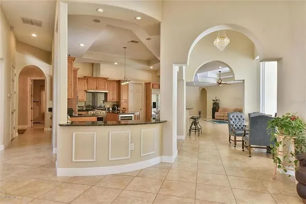 a large white kitchen with a large window and chairs