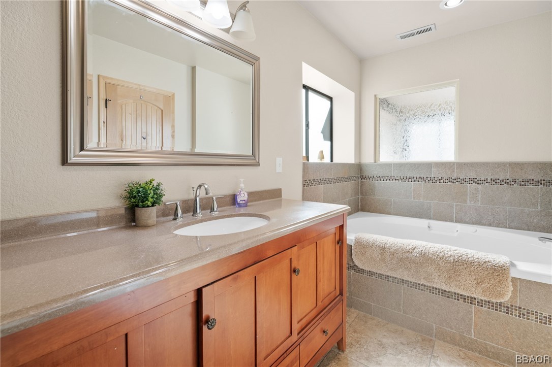 368 Pulaski Road Big Bear Lake, CA 92315 - Photo 23 of 44 a bathroom with a granite countertop bathtub sink and mirror