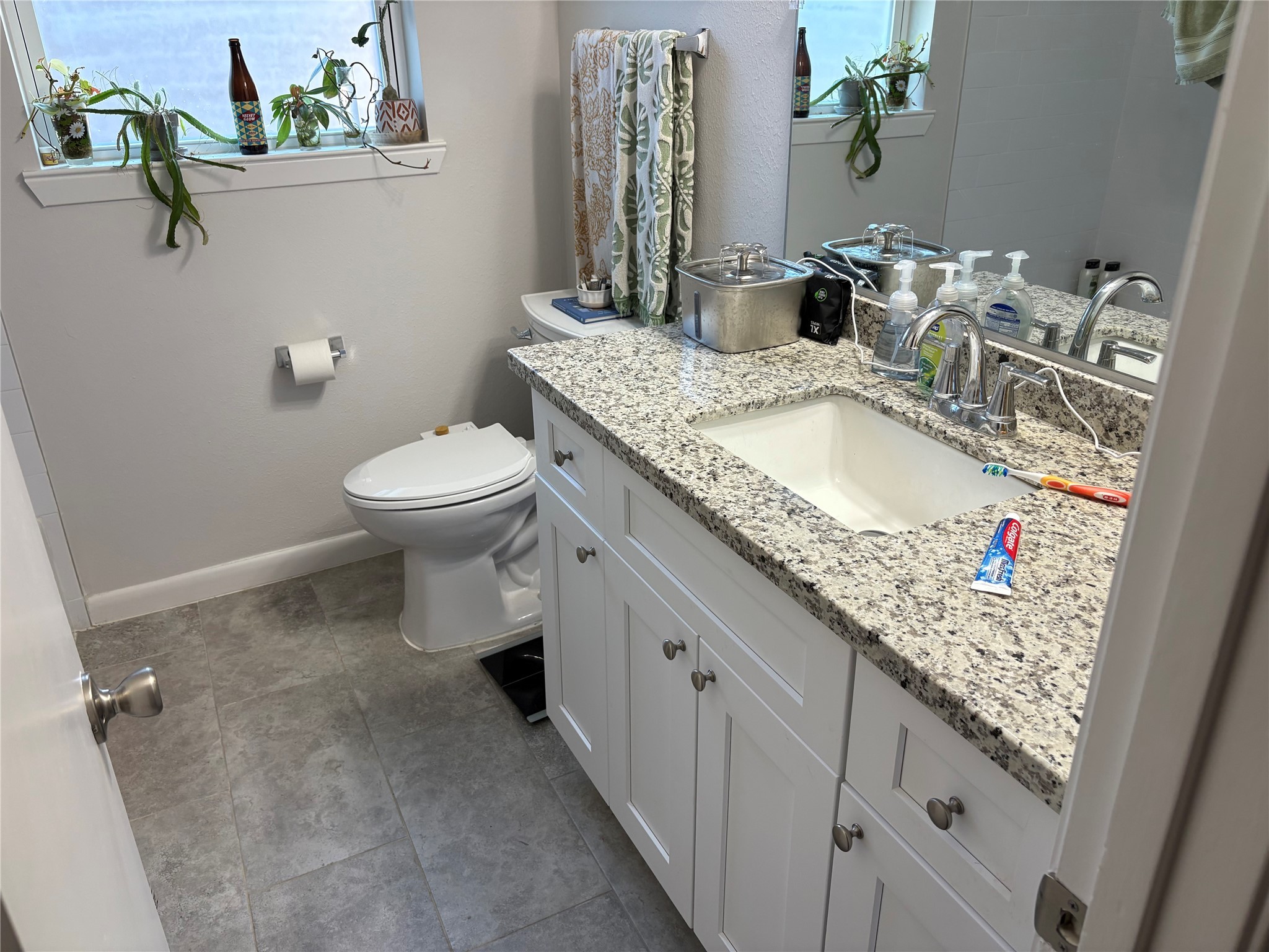 9530 Emnora Lane Houston, TX 77080 - Photo 9 of 16 a bathroom with a granite countertop sink a toilet and a mirror