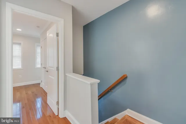 a view of a hallway with wooden floor and staircase