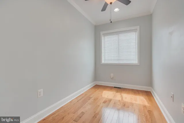 an empty room with a window and wooden floor