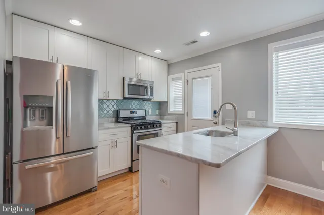 a kitchen with stainless steel appliances a refrigerator sink and microwave