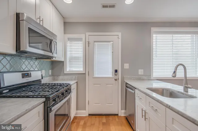 a kitchen with granite countertop a sink stove and cabinets