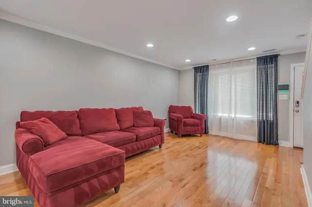 a living room with furniture and a wooden floor