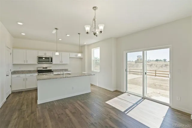 a kitchen with stainless steel appliances granite countertop a stove a sink and a refrigerator