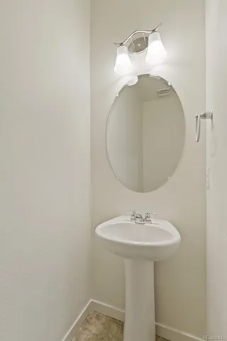a bathroom with a sink a mirror and a lamp