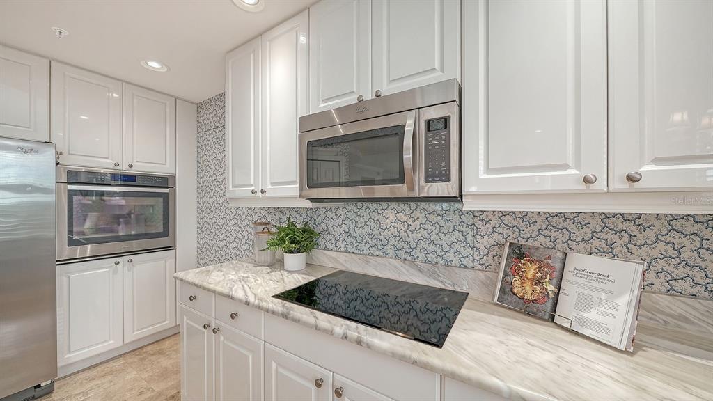 385 North Point Road, Unit 701 Osprey, FL 34229 - Photo 42 of 97 a kitchen with stainless steel appliances granite countertop a sink stove and microwave