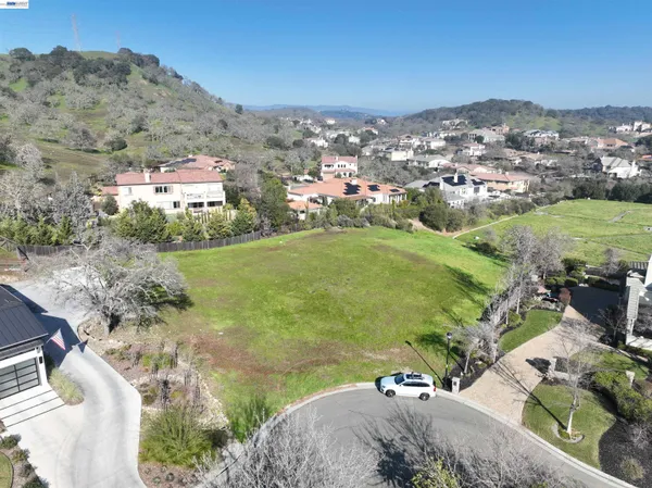 an aerial view of residential houses with outdoor space and trees
