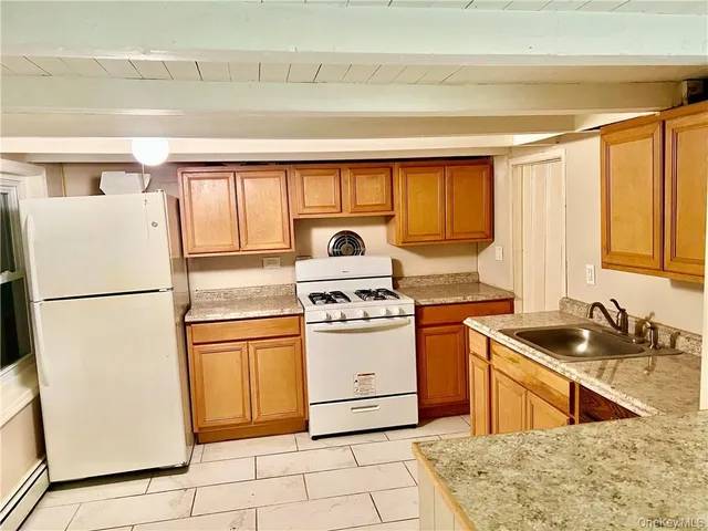 a kitchen with granite countertop white cabinets and white appliances