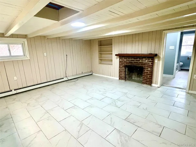 a view of an empty room with a fireplace and a window