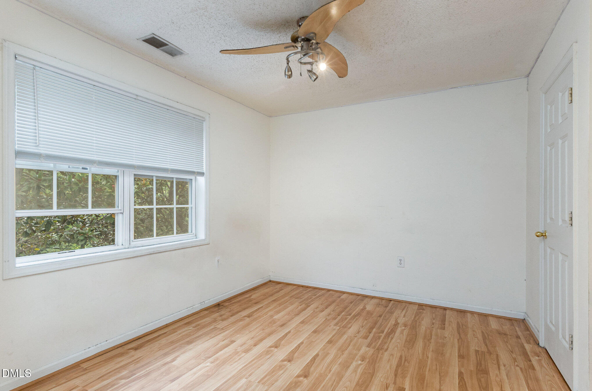 2011 Wolfmill Drive, Unit 301 Raleigh, NC 27603 - Photo 6 of 12 a view of an empty room with wooden floor and a window