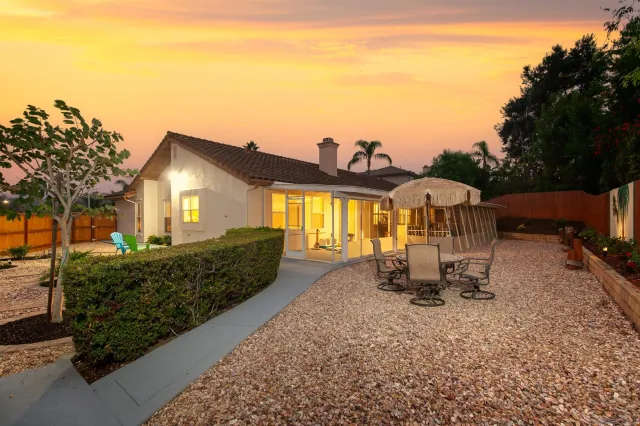 a view of a house with backyard and sitting area