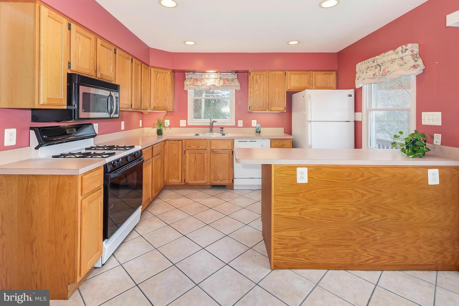 11520 Joseph Mill Road Silver Spring, MD 20906 - Photo 6 of 30 a kitchen with a stove a sink and a refrigerator
