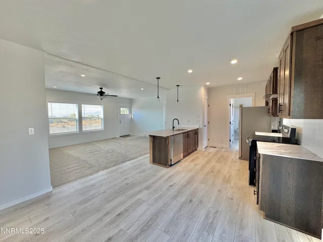 a large kitchen with stainless steel appliances kitchen island a large counter top and a wooden floors