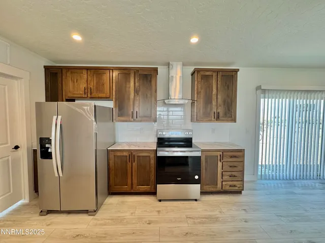 a kitchen with stainless steel appliances granite countertop a refrigerator a stove and a sink with wooden floor