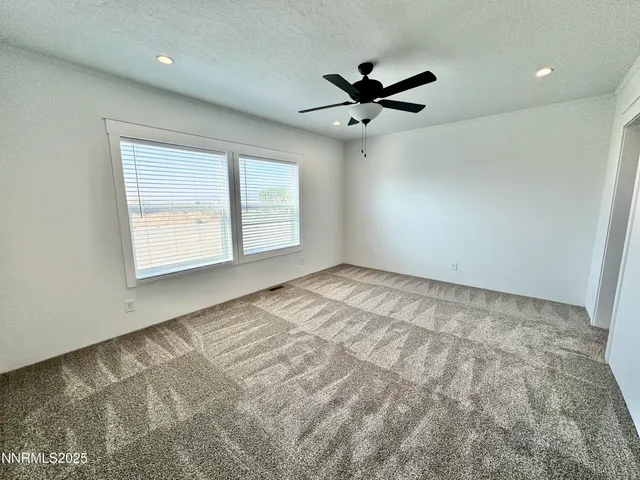 a view of empty room with window and ceiling fan