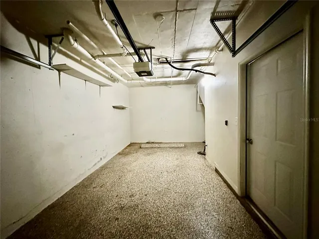 a view of a swimming pool with lawn chairs under an umbrella