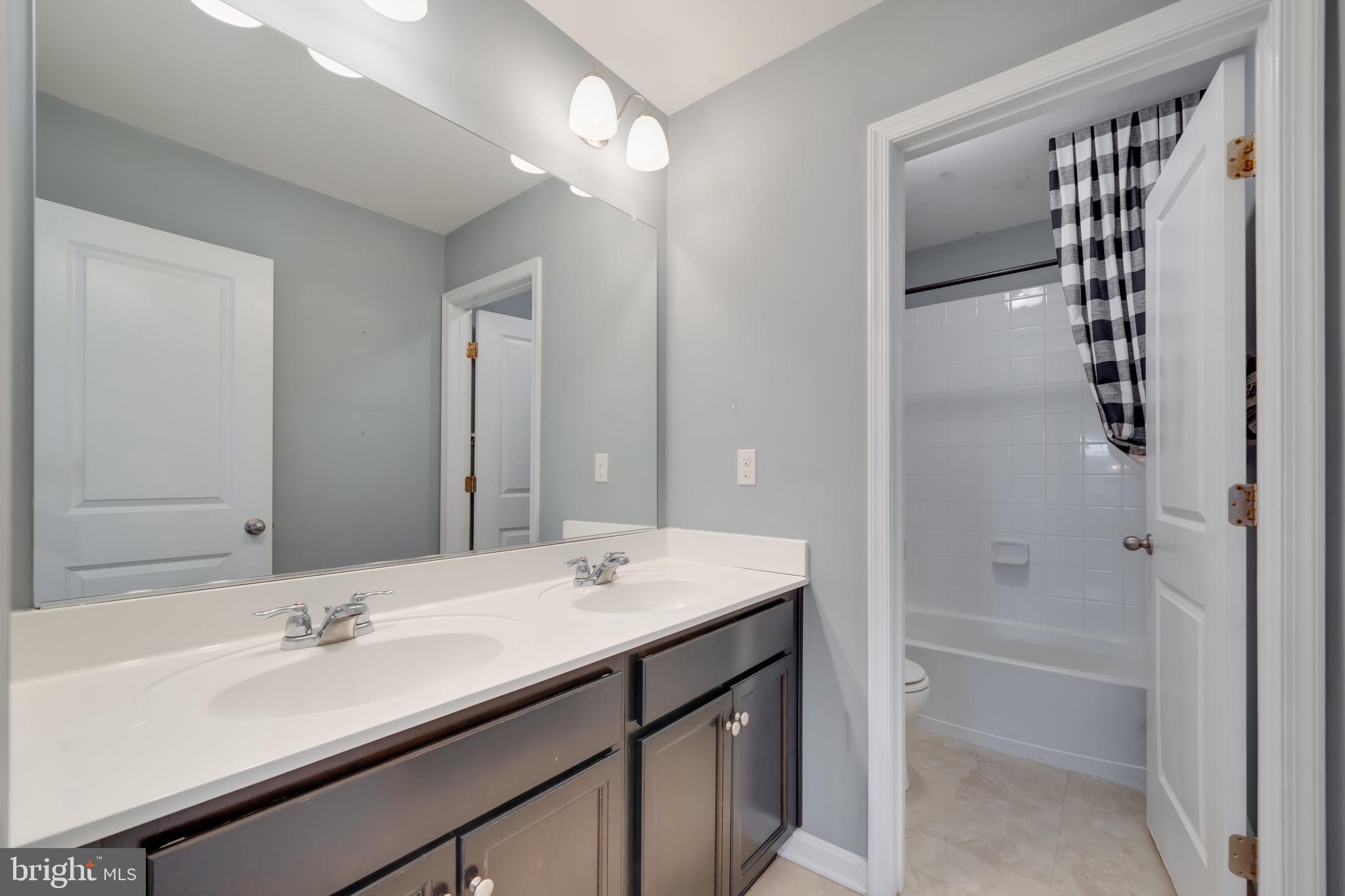 800 Naeve Court Accokeek, MD 20607 - Photo 37 of 56 a bathroom with a double vanity sink a large mirror and shower