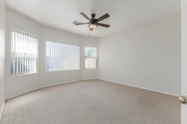 an empty room with a window and a ceiling fan