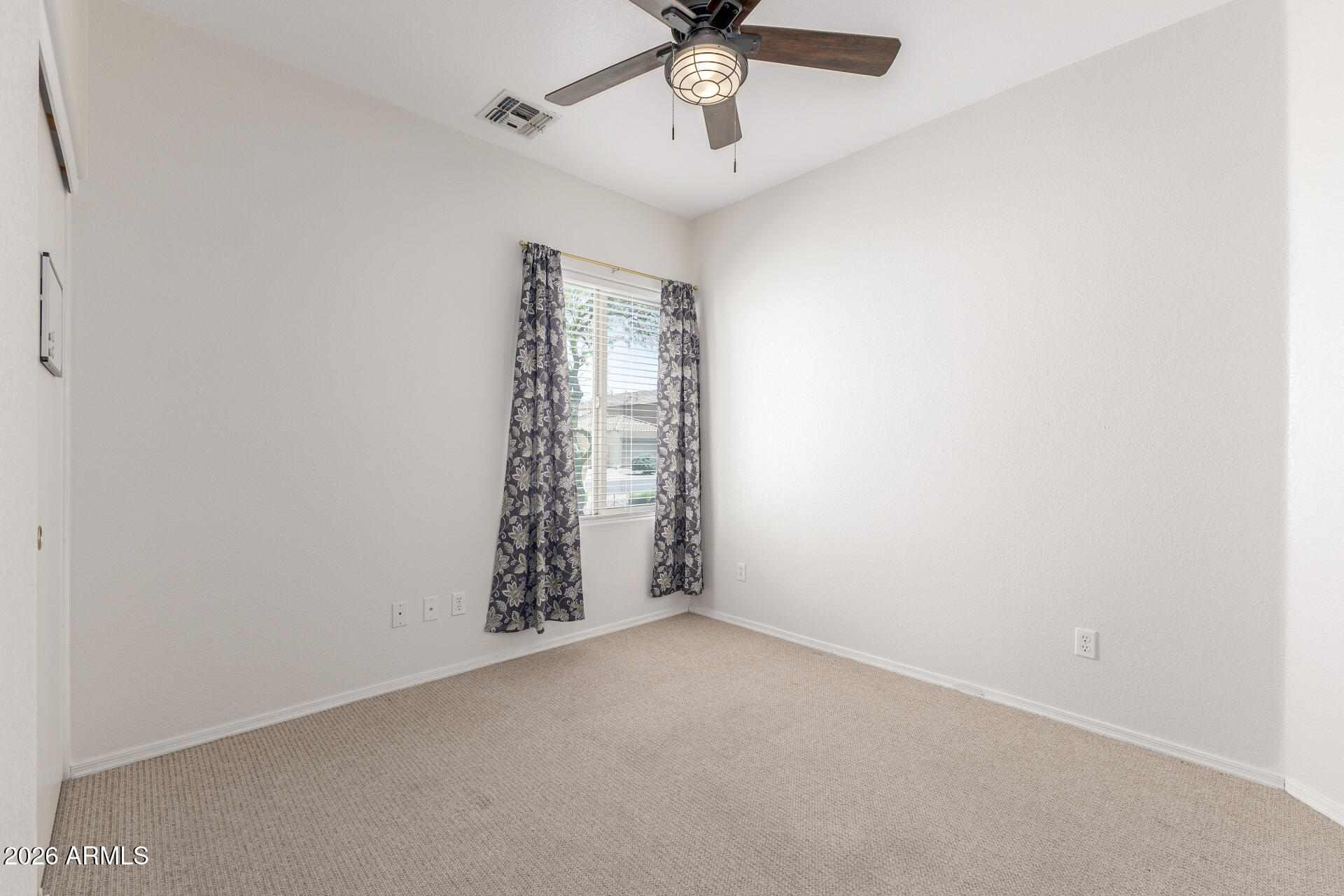 256 North 110th Street Apache Junction, AZ 85120 - Photo 16 of 27 an empty room with a ceiling fan and carpet