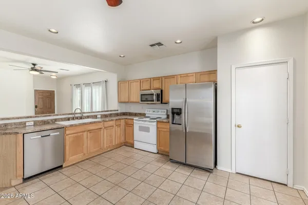 a kitchen with stainless steel appliances granite countertop a refrigerator and a sink