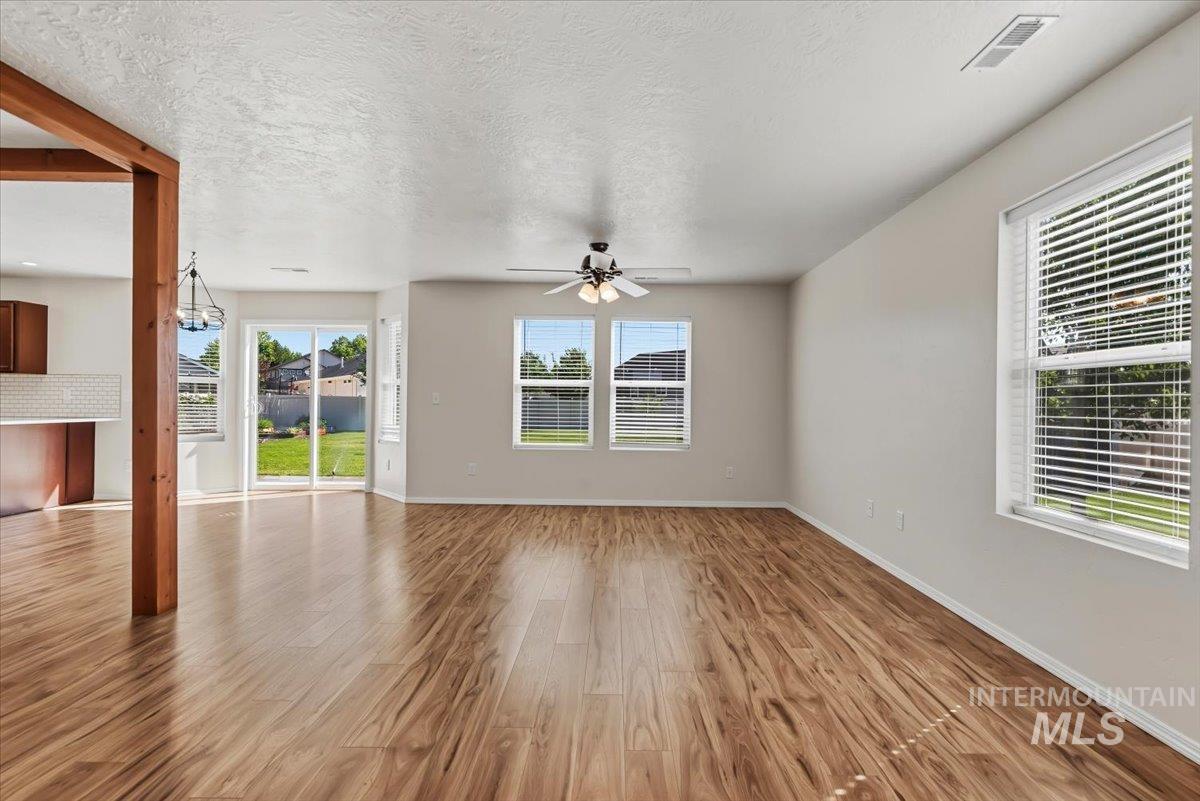 12310 West Hidden Point Drive Star, ID 83669 - Photo 30 of 48 Spacious living area featuring wood-finish flooring, light neutral wall tones, and multiple windows with blinds