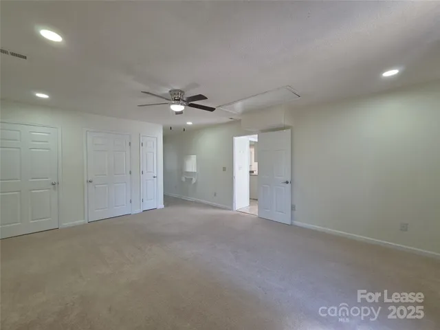 an empty room with a ceiling fan and a bathroom