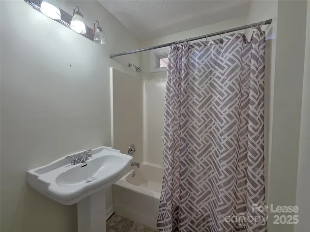 a bathroom with a sink and mirror with toilet