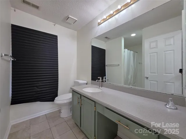 a bathroom with a sink a toilet and mirror