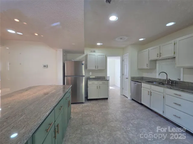 a open kitchen with granite countertop a sink and white stainless steel appliances