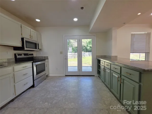 a kitchen with stainless steel appliances kitchen island granite countertop a stove a sink and a refrigerator