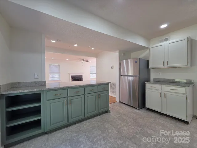 a kitchen with refrigerator and cabinets