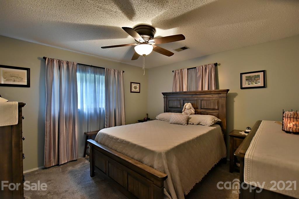 407 Laurel Hills Road Indian Land, SC 29707 - Photo 14 of 26 a bedroom with a bed and a chandelier