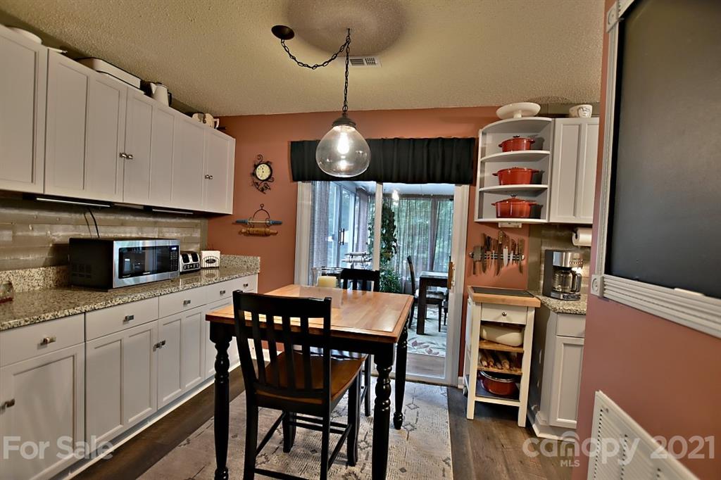 407 Laurel Hills Road Indian Land, SC 29707 - Photo 6 of 26 a kitchen with stainless steel appliances granite countertop a dining table chairs and white cabinets