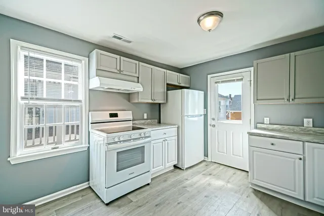a kitchen with white cabinets and white appliances