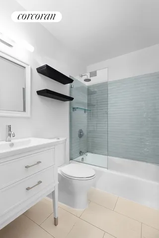 a bedroom with a bed table flowerpot and a window