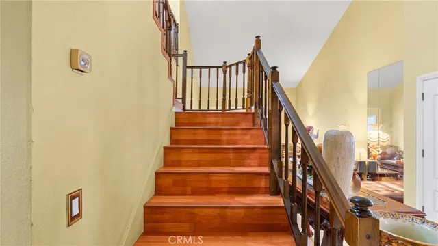 a view of staircase with lots of frames on wall and windows