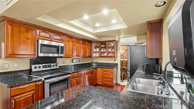 a kitchen with stainless steel appliances granite countertop a sink stove and refrigerator