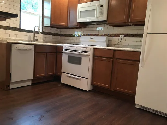 a kitchen with stainless steel appliances granite countertop a sink a stove a microwave and cabinets