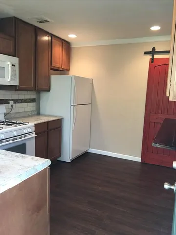 a kitchen with stainless steel appliances a refrigerator and a stove top oven