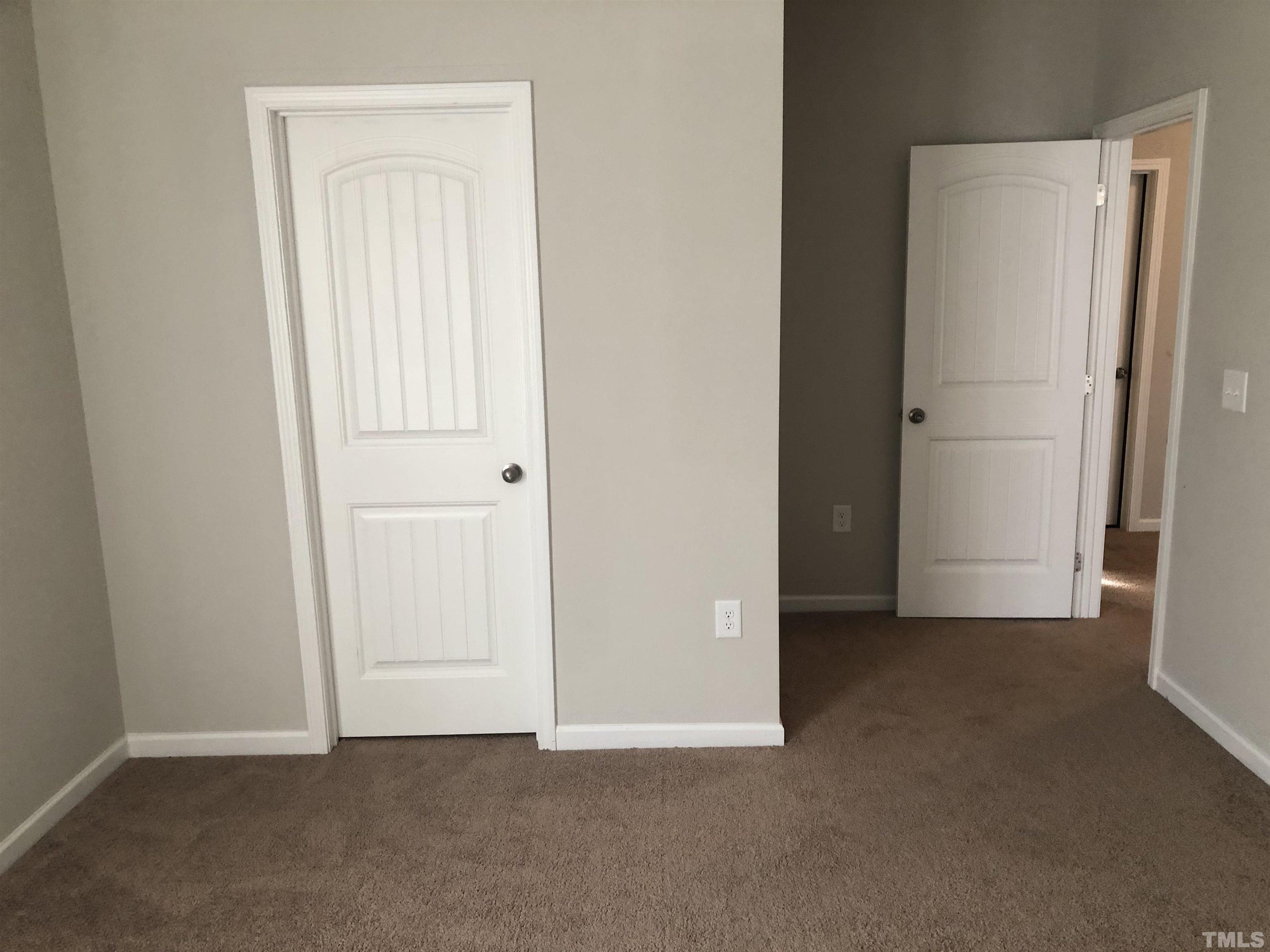 6830 Resting Grove Road Raleigh, NC 27610 - Photo 18 of 20 an empty room with closet and a door