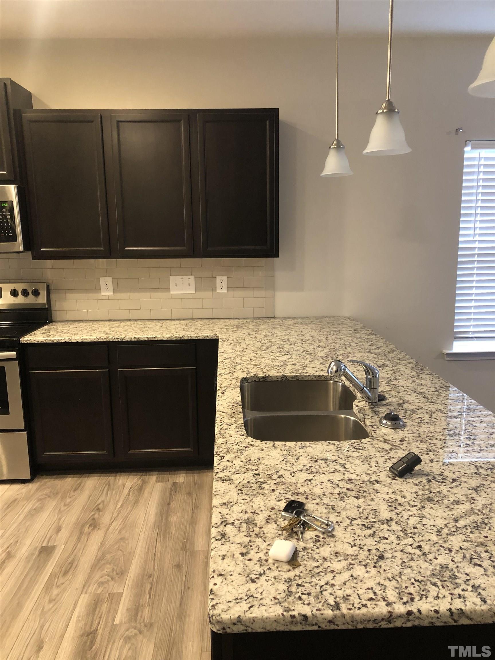 6830 Resting Grove Road Raleigh, NC 27610 - Photo 7 of 20 a kitchen with stainless steel appliances granite countertop a sink and a microwave