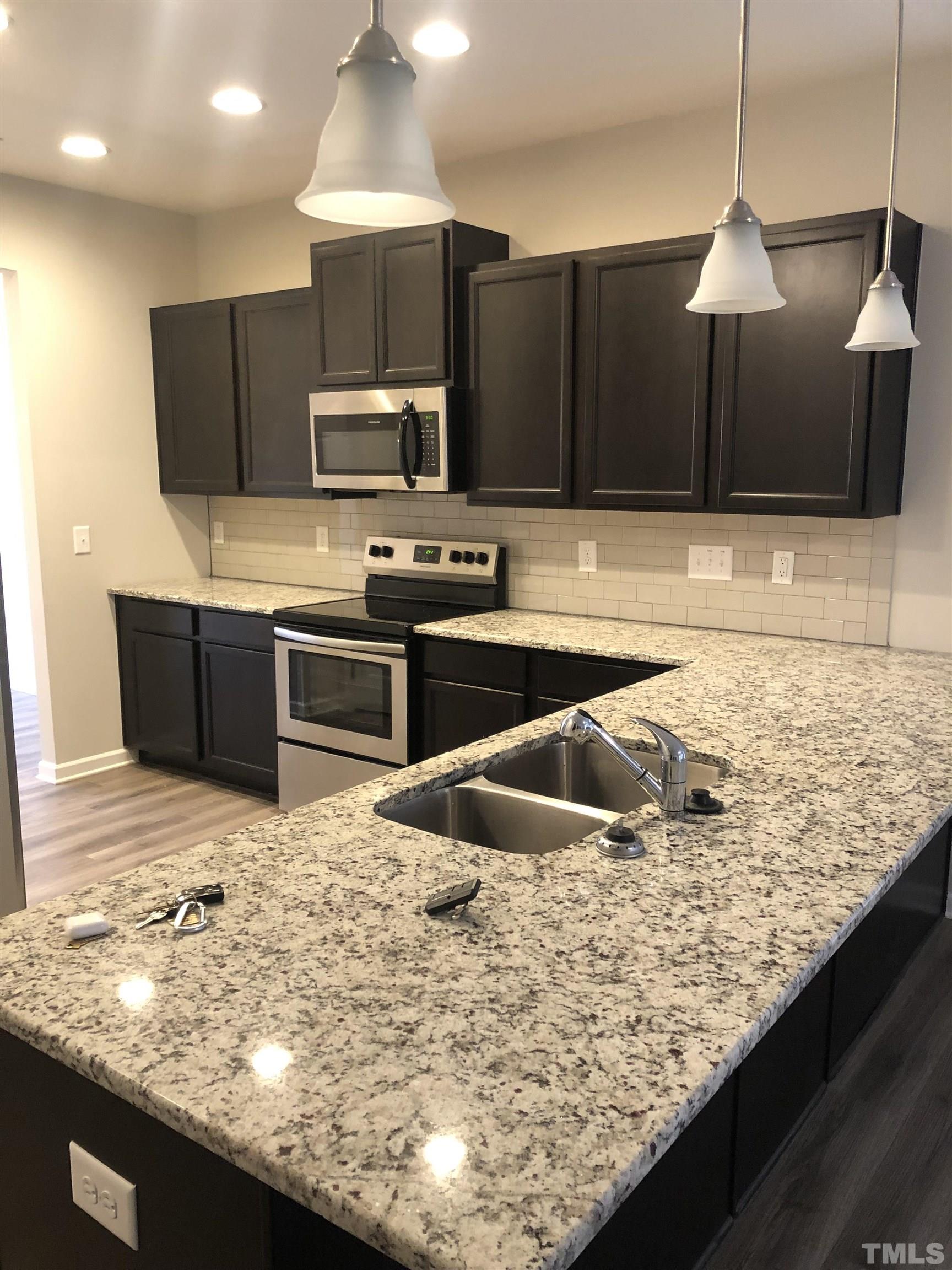 6830 Resting Grove Road Raleigh, NC 27610 - Photo 8 of 20 a kitchen with kitchen island granite countertop a sink and counter space