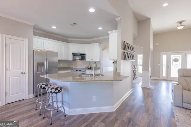 a kitchen with stainless steel appliances white cabinets and window