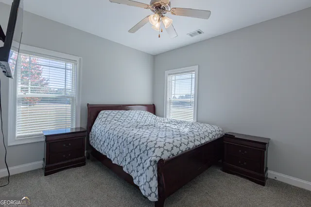 a bathroom with a granite countertop sink a toilet and a window