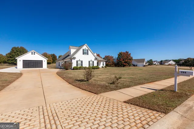 a view of white house with a yard