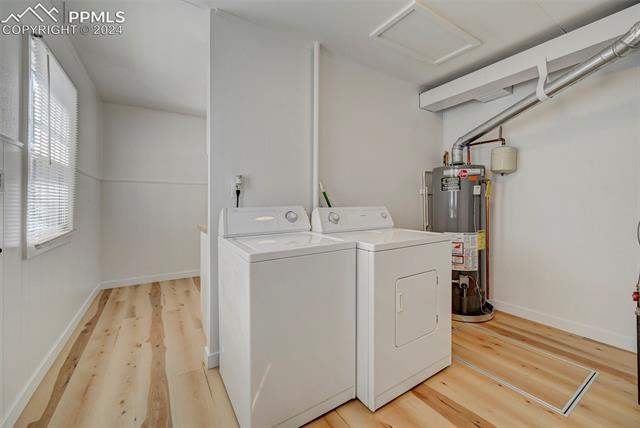 507 East Cheyenne Road Colorado Springs, CO 80905 - Photo 18 of 25 Laundry room with plenty of natural light, light hardwood / wood-style flooring, water heater, and washer and clothes dryer